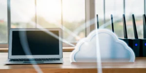 Laptop and cloud icon on a desk for business cloud migration services.