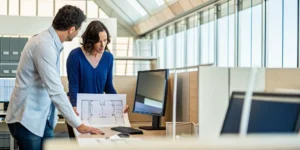 Planning how many network drops an office needs by reviewing a floor plan on a desk.
