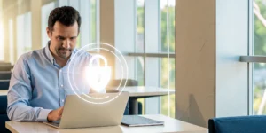 Small business owner reviewing cybersecurity protection plan on laptop in a modern office